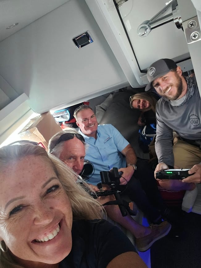 BoatTest Crew hideing in the cabin of the Formula 360 CBR while the videographer flies the drone